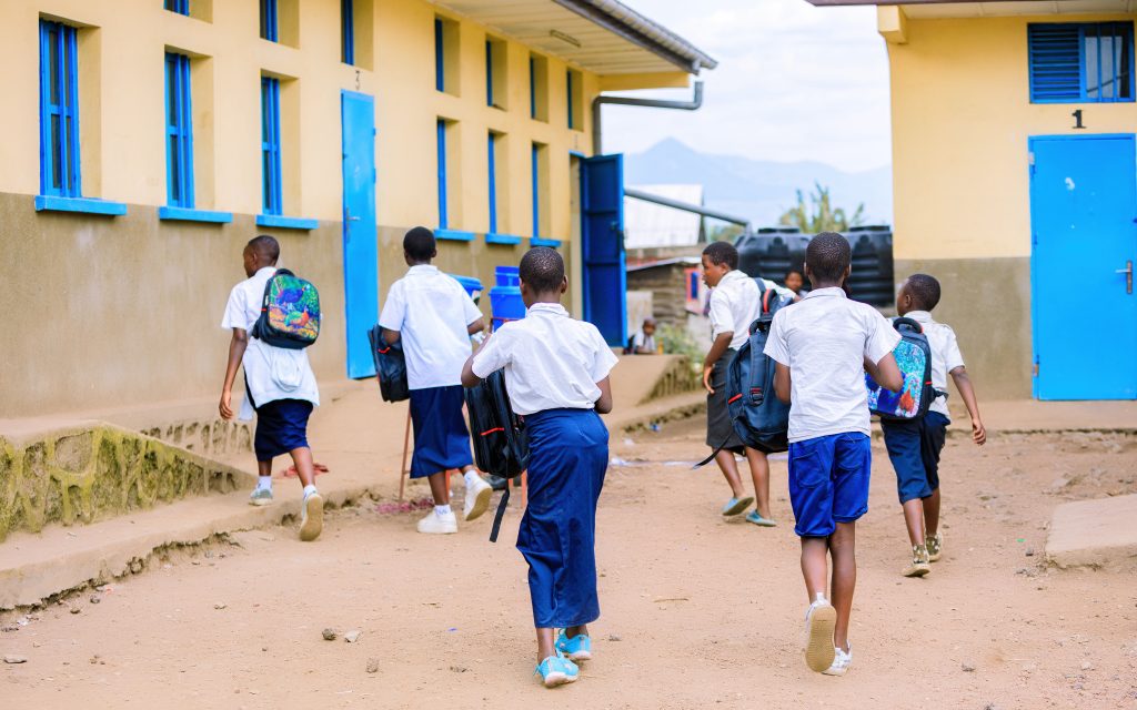 Children walking at a school in uniforms.